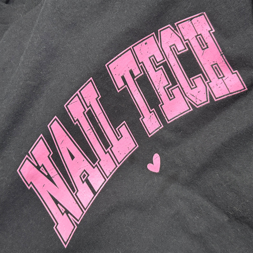 Gray sweatshirt with pink 'NAIL TECH' text and a heart on a dark background